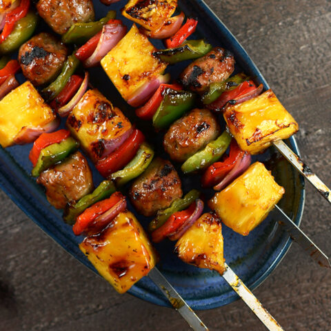 Plate with four skewers with meatballs and banana