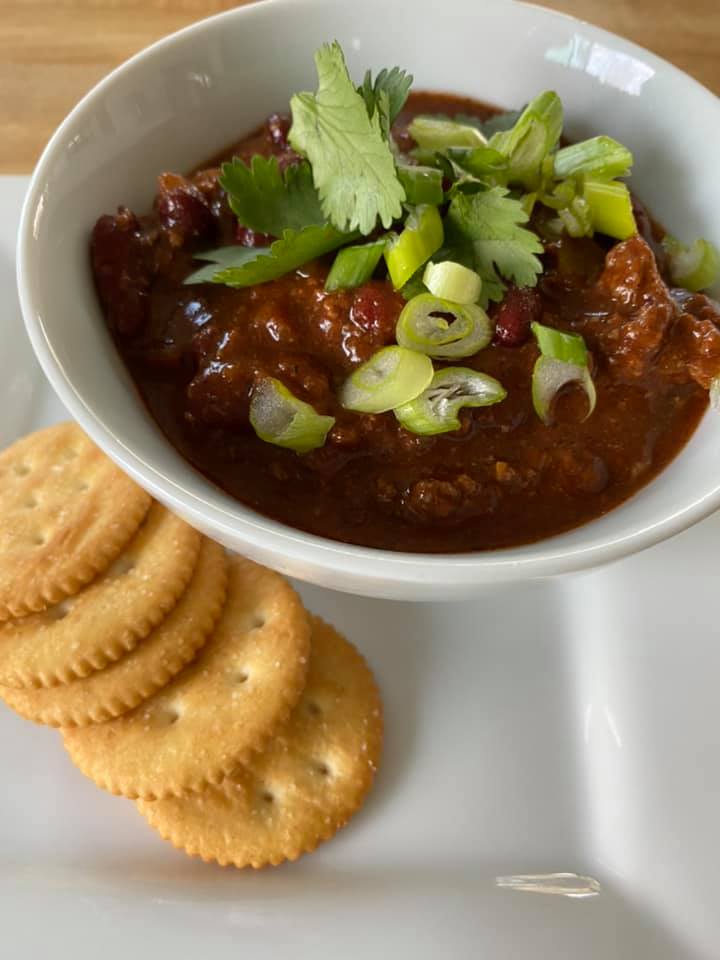 Salsa in a bowl with 4 crackes on the side 