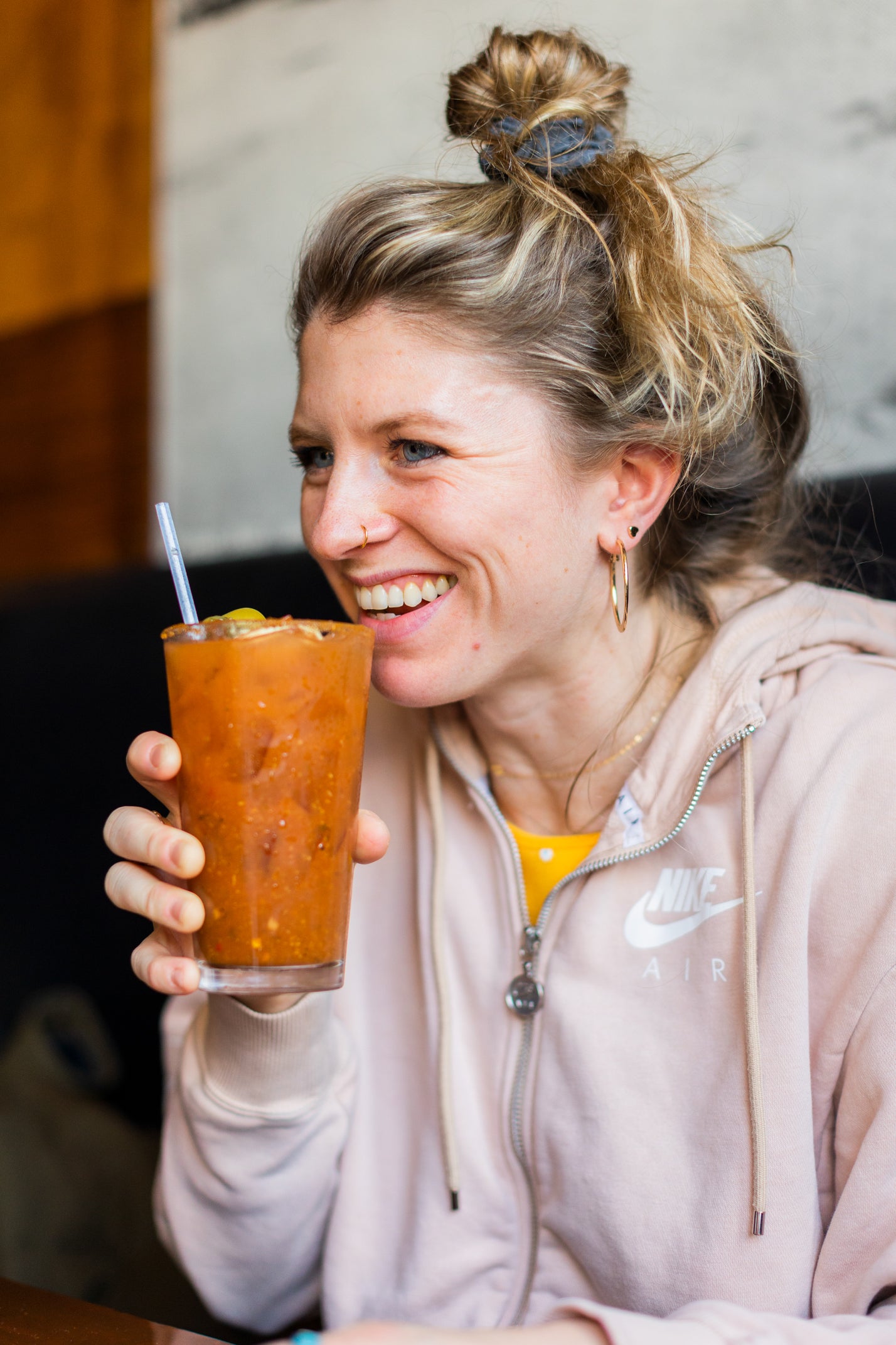 Woman smiling and drinking a Lovejoy's Bloody Mary.